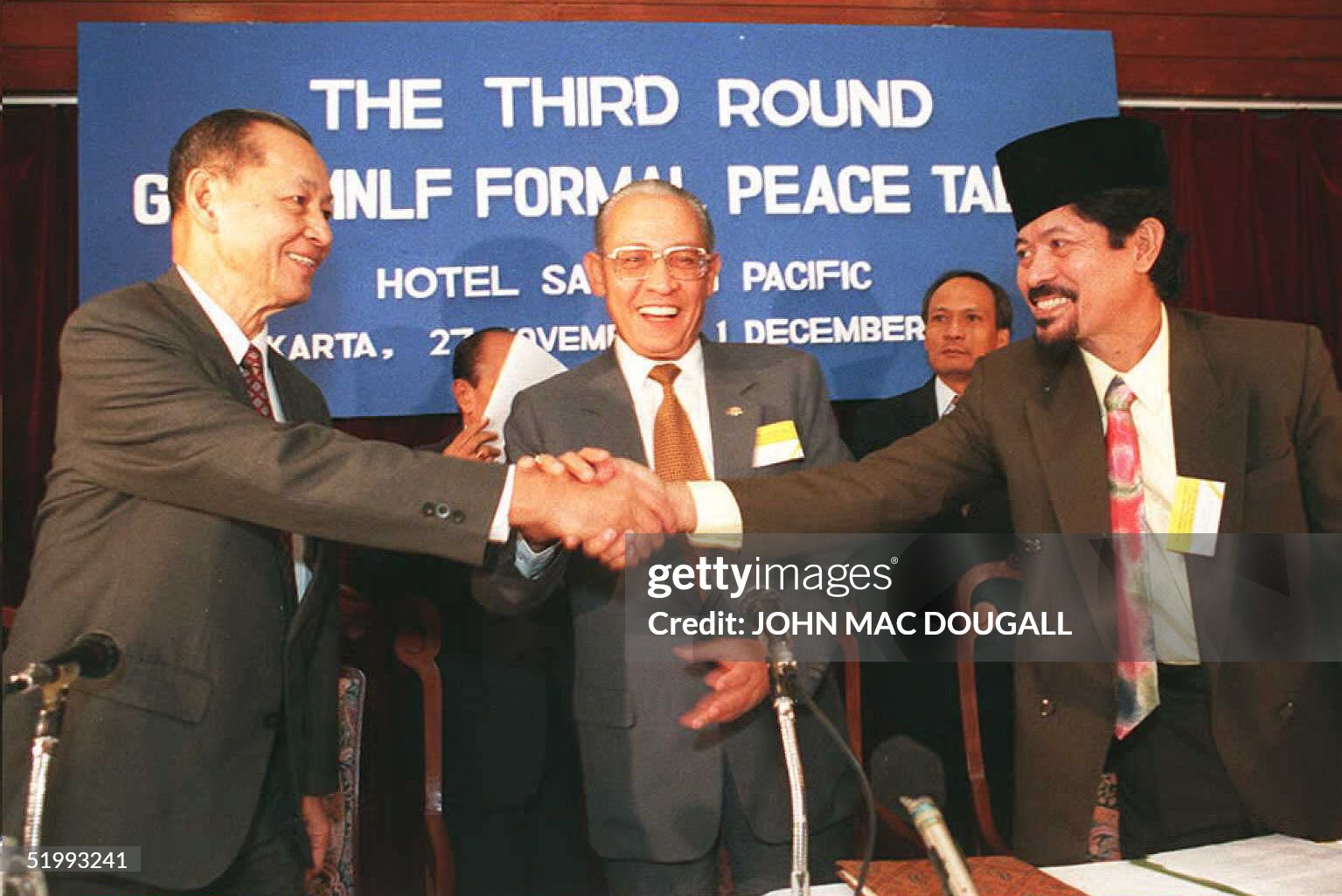 JAKARTA, INDONESIA - NOVEMBER 27: Head of the Moro National Liberation Front (MNLF) delegation Professor Nur Misuari (R) and Manuel T. Yan (L), head of the Philippines Governnment delegation shake hands as Indonesian Foreign Minister Ali Alatas looks on prior to the inaugural session of the 3rd round of formal peace talks 27 November aimed at achieving autonomous status for the southern Philippines island of Mindanao. The peace talks are scheduled to last for four days. AFP PHOTO (Photo credit should read JOHN MACDOUGALL/AFP via Getty Images)
